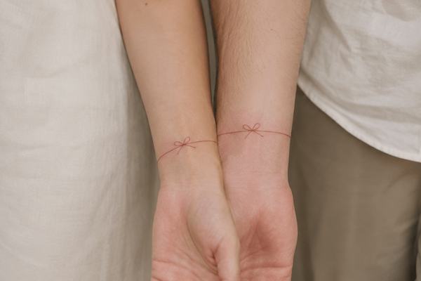 Feine Schleifen-Tattoos am Handgelenk