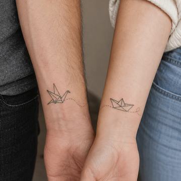 Kleine Papierboot-Tattoos am Handgelenk