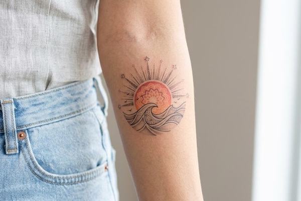 Sonnenaufgang-Tattoo am Unterarm