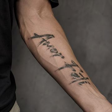 Unterarm mit großem „Amor Fati“-Tattoo
