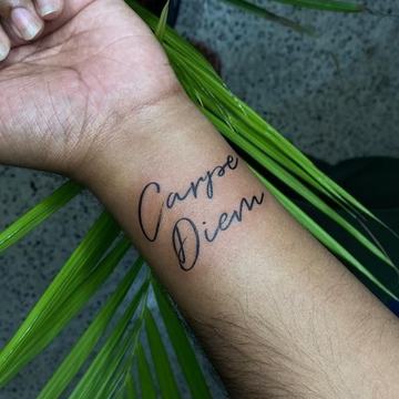 Kleines Carpe-Diem-Tattoo am Handgelenk