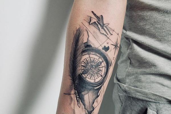 Kompass-Tattoo mit Feder am Unterarm