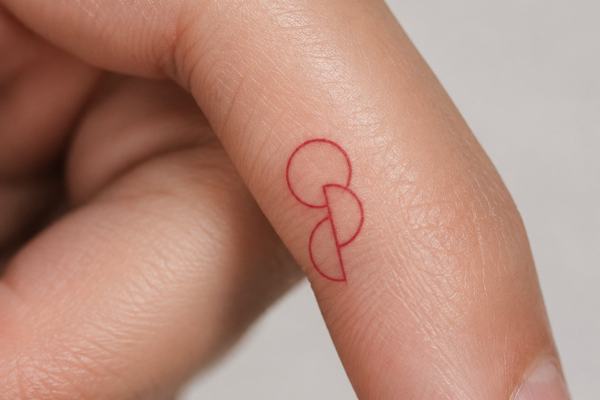 Nahaufnahme eines seitlichen Fingers mit kleinem, rotem Fineline‑Tattoo