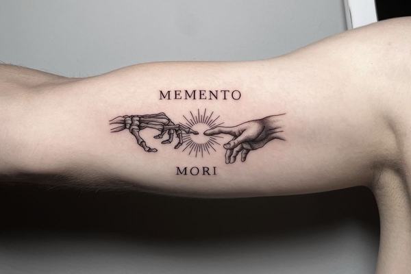 Memento‑Mori‑Tattoo am inneren Oberarm