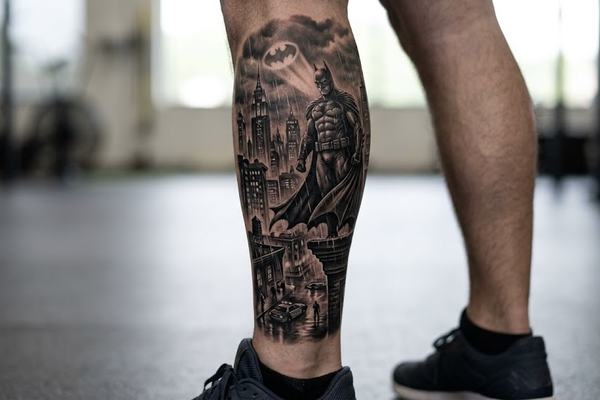 Kontrastreiches Schwarz-Grau-Batman-Tattoo auf der Wade