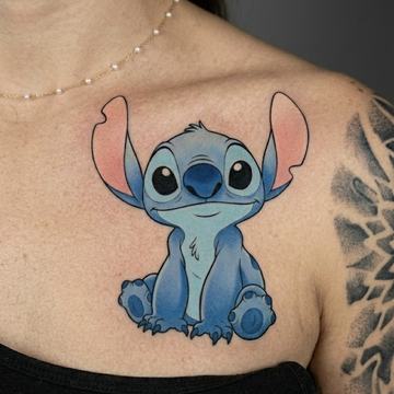 Großes, farbiges Stitch-Tattoo im Cartoon-Stil auf der linken oberen Brust nahe dem Schlüsselbein