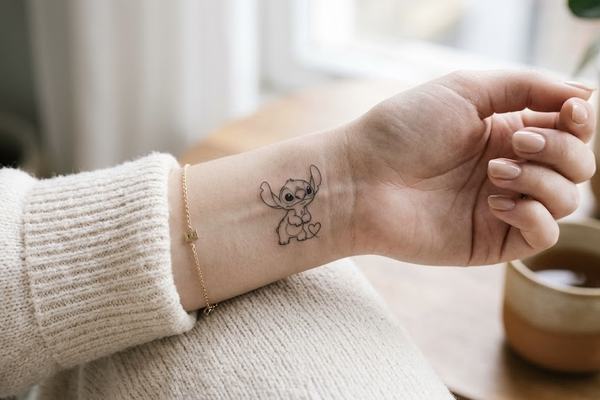 Zartes, kleines Stitch-Tattoo im Fineline-/Outline-Stil mit kleinem Herz 