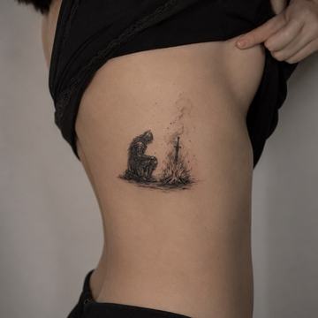 Kleines Schwarz‑Grau‑Tattoo an der Rippe