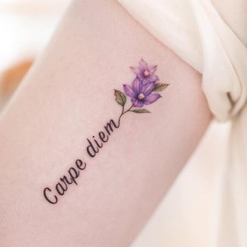 Reduziertes Carpe-Diem-Tattoo mit floralen Elementen