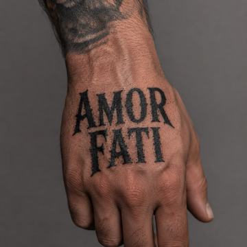 Handrücken mit großem „AMOR FATI“-Tattoo in schwarzer