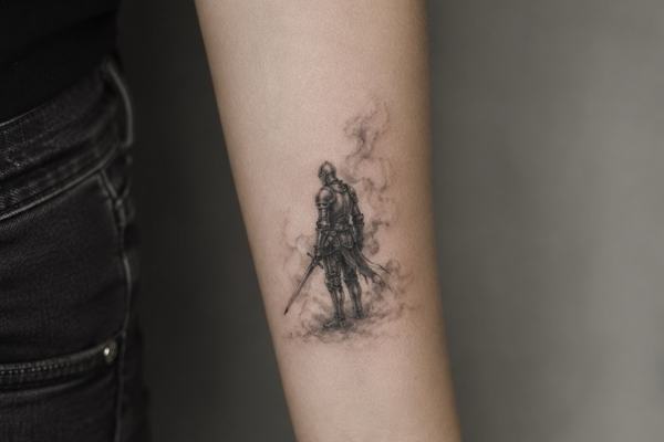 Kleines Schwarz‑Grau-Tattoo am Unterarm