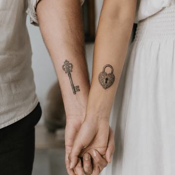 Partner-Tattoo mit Schlüssel und Schloss am Unterarm