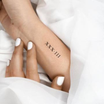Feines Datum Tattoo am Handgelenk