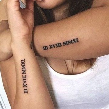 Römische Zahlen Tattoo am Oberarm
