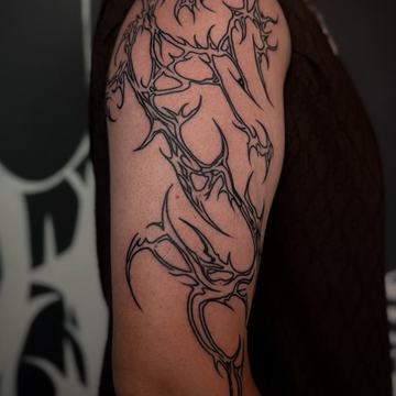 Lineares Tribal Tattoo am Oberarm