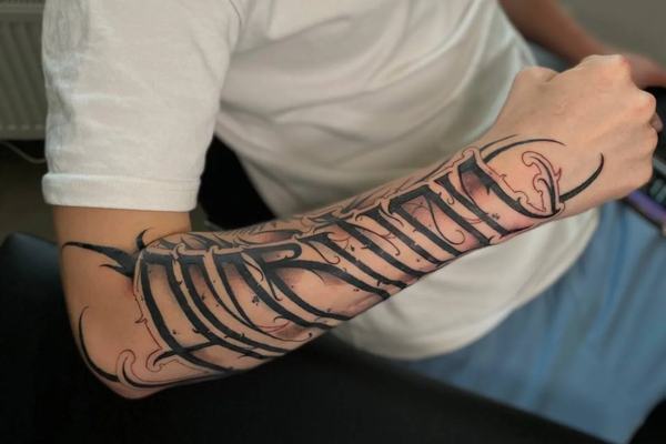 Großes Lettering-Tattoo auf dem Unterarm